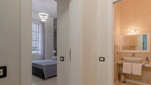Un dormitorio moderno con una cama, una mesita de noche y un ventanal con cortinas.