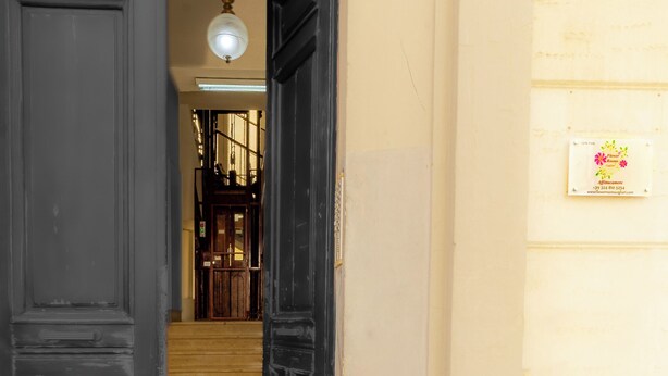 Un pasillo con una puerta negra que da a una escalera.
