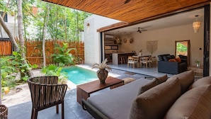 A modern outdoor living area with a pool, seating, and a dining area. - Luxury 2BR Villa with Private Pool, Spacious Living & Modern Amenities (Tulum)