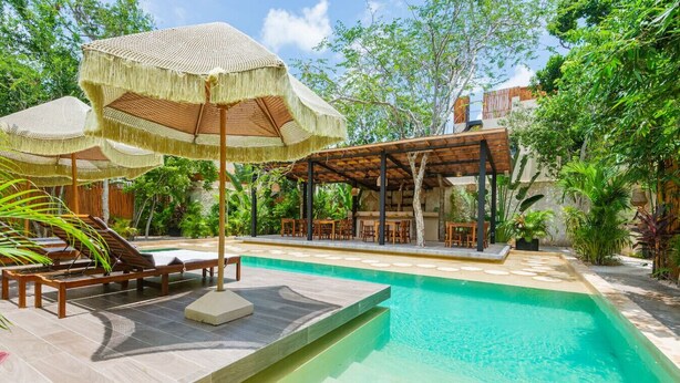 A pool area with lounge chairs, umbrellas, and a covered seating area. - Luxury 2BR Villa with Private Pool, Spacious Living & Modern Amenities (Tulum)