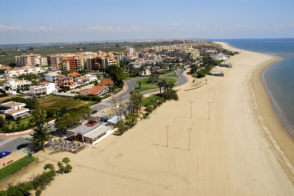Eine Küstenregion mit Strandhäusern, einer Hauptstraße und einem Strand.