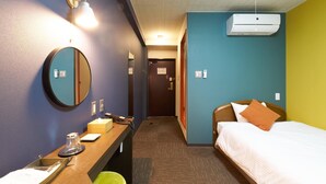 A hotel room with a bed, bedside table, mirror, and a wall-mounted air conditioner. - STATION Tajima (Asago)
