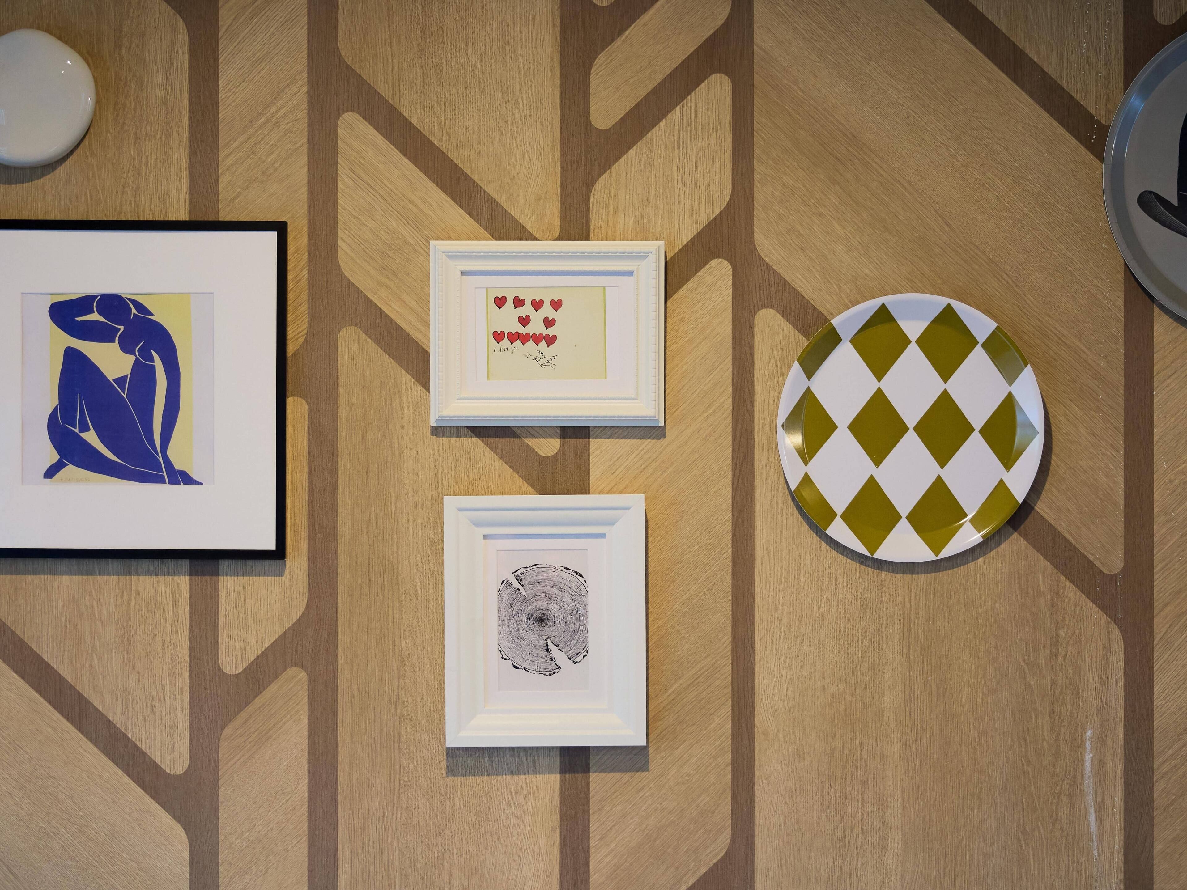 Three framed artworks on a wooden wall.