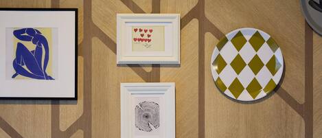 Three framed artworks on a wooden wall.