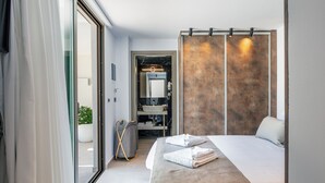 A modern hotel room with a large bed, a bathroom with a large mirror, and a view of the outdoors. - Casa del Balo - Harmony in Nature by etouri (Chania)