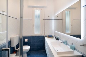 Une salle de bain avec des toilettes, un lavabo et un miroir.