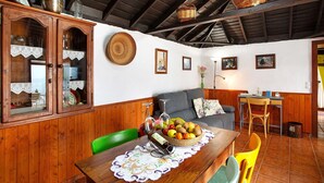 Un comedor con una mesa de madera, sillas y un aparador con puertas de cristal.