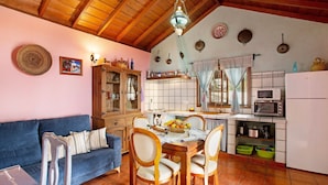 A cozy kitchen with a dining table, chairs, and a blue sofa. - Holiday Home 'La Roquina' with Sea View, Wi-Fi and Air Conditioning (Tijarafe)