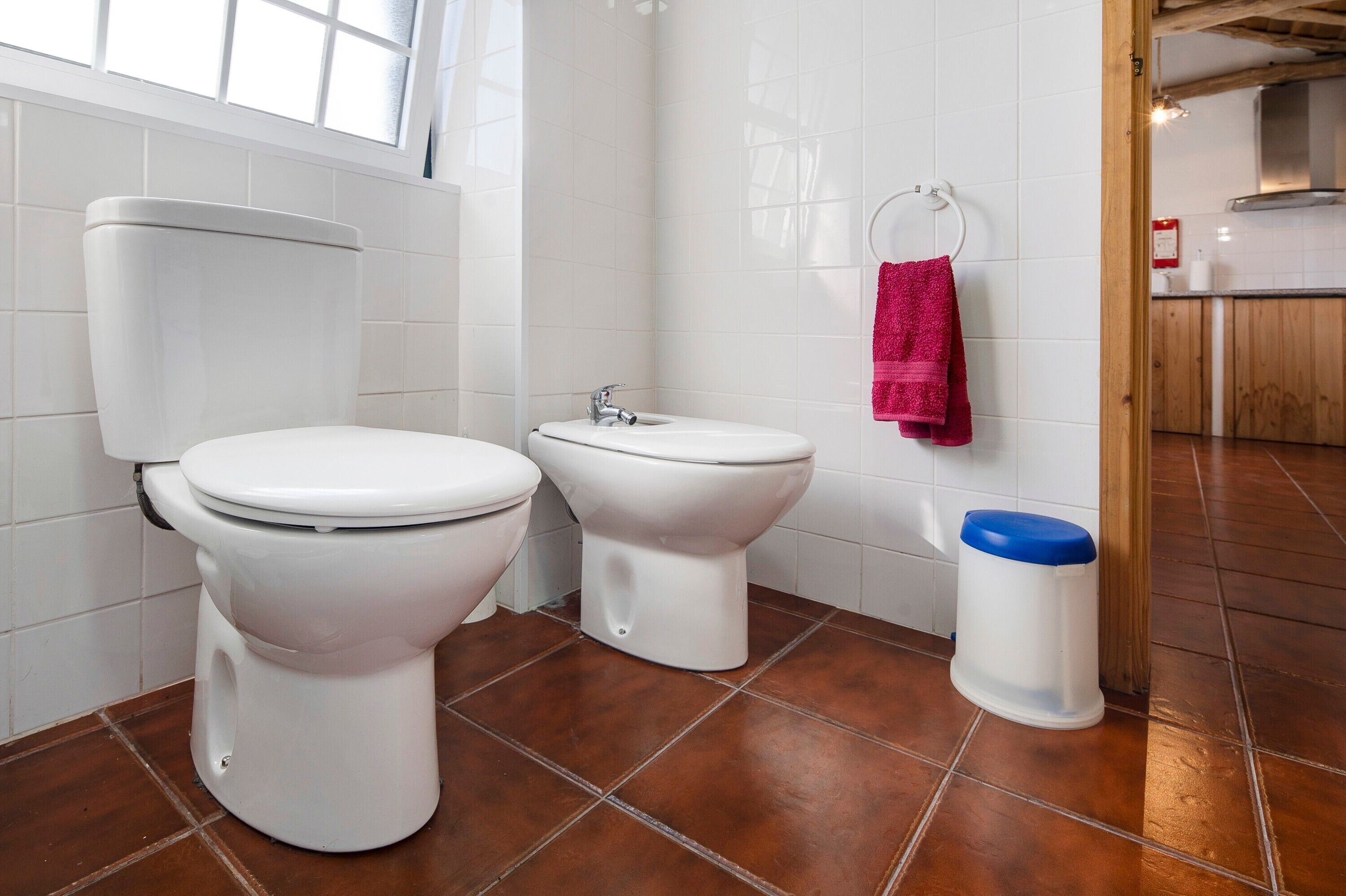 Een badkamer met toilet, bidet en prullenbak.