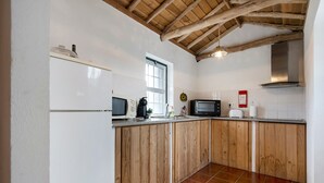 Una cocina con armarios de madera, un refrigerador, un microondas y una estufa.