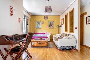 A living room with a wooden coffee table, a sofa, a chair, and a dining table. - Apartment 'San Antonio' with Private Terrace, Wi-Fi and Air Conditioning (Sedaví)