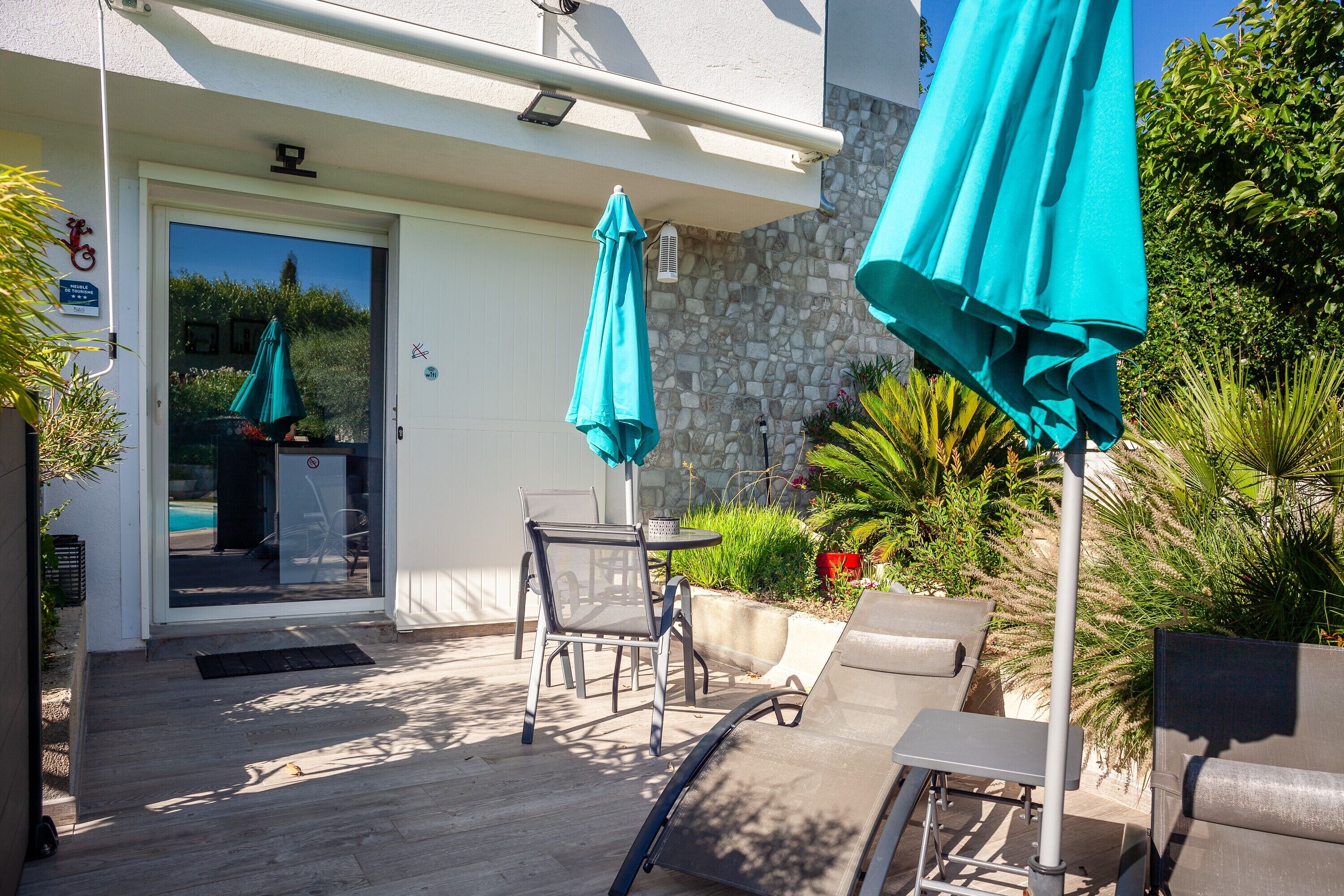 A patio with outdoor seating, a door, and a pool visible through the glass.
