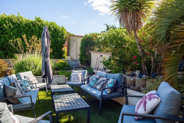 An outdoor patio with seating, a table, and a covered umbrella. - Apartment 'Lucerta Bella' with Shared Pool, Wi-Fi and Air Conditioning (Aix-en-Provence)