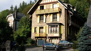 Un bâtiment en pierre avec une enseigne indiquant « COTTAGE » et un balcon.