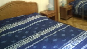 Une chambre à coucher avec un lit, une table de chevet, une lampe et un miroir.