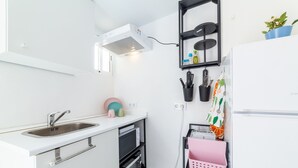 Una cocina compacta con un lavamanos, estufa y una pequeña encimera.
