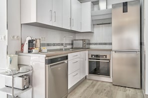 A modern kitchen with stainless steel appliances, a dishwasher, a microwave, and a toaster. - Holiday Home 'Entre Montañas' with Mountain View, Wi-Fi and Air Conditioning (Archez)