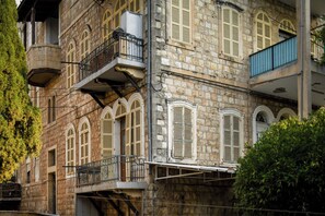A multi-story stone building with arched windows and balconies.