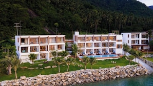 Un resort moderno con varias edificaciones, una piscina y un litoral rocoso.