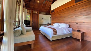 A bedroom with a wooden ceiling, a bed with white bedding, a bedside table, and a television on a stand. - Saujana Private Villas (Langkawi)