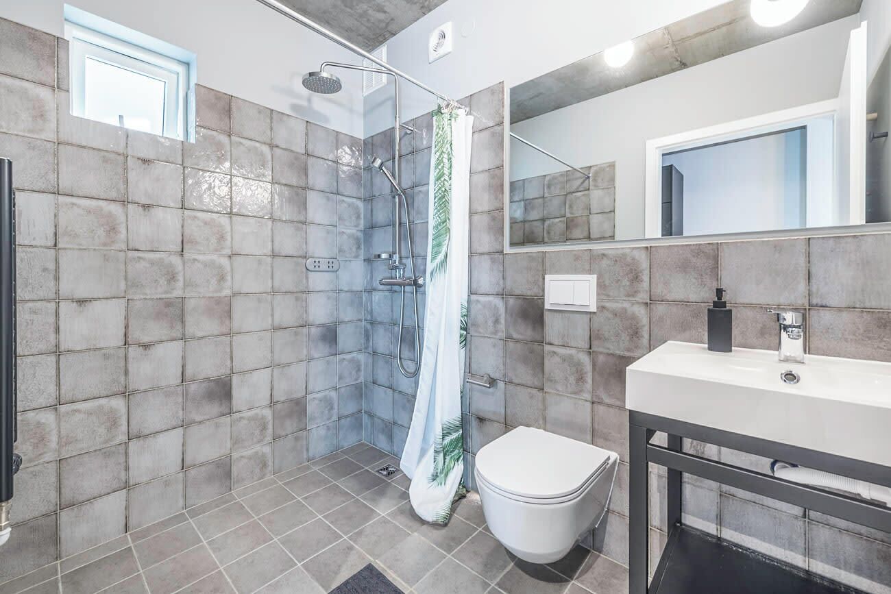 Un baño moderno con ducha, inodoro y lavamanos.