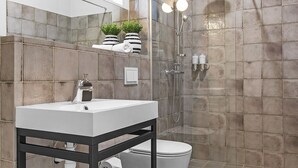 A modern bathroom with a shower, toilet, and sink. - Backyard Stylish Studio for 2 - Excellent Location (Reykjavík)