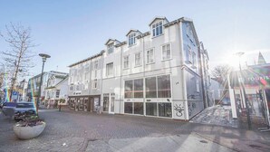 A multi-story building with large windows and a ground-level entrance. - Backyard Stylish Studio for 2 - Excellent Location (Reykjavík)