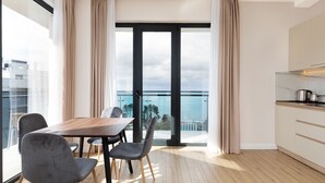 Un apartamento moderno con comedor, cocina y balcón con vista a la ciudad.