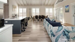 A spacious living area with a kitchen, dining table, and seating area. - Pet-Friendly, WiFi & Pool Table | Two Salty Dogs (Lilli Pilli)