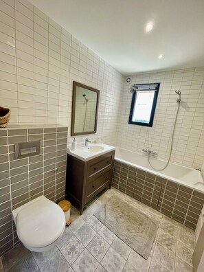 Een haardroger, handdoeken, zeep, toiletpapier