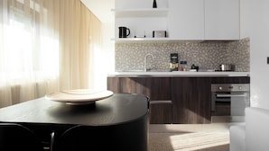 A modern kitchen with a stone backsplash, white cabinets, and a built-in oven.