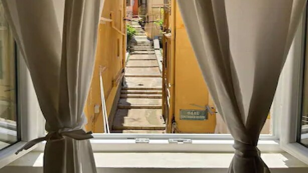 A narrow alleyway between buildings with a window at the end. - THE CENTRIC Apt. by LOC HOSPITALITY (Corfu)
