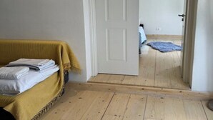 A room with a bed, a door leading to another room, and a wooden floor. - THE CENTRIC Apt. by LOC HOSPITALITY (Corfu)