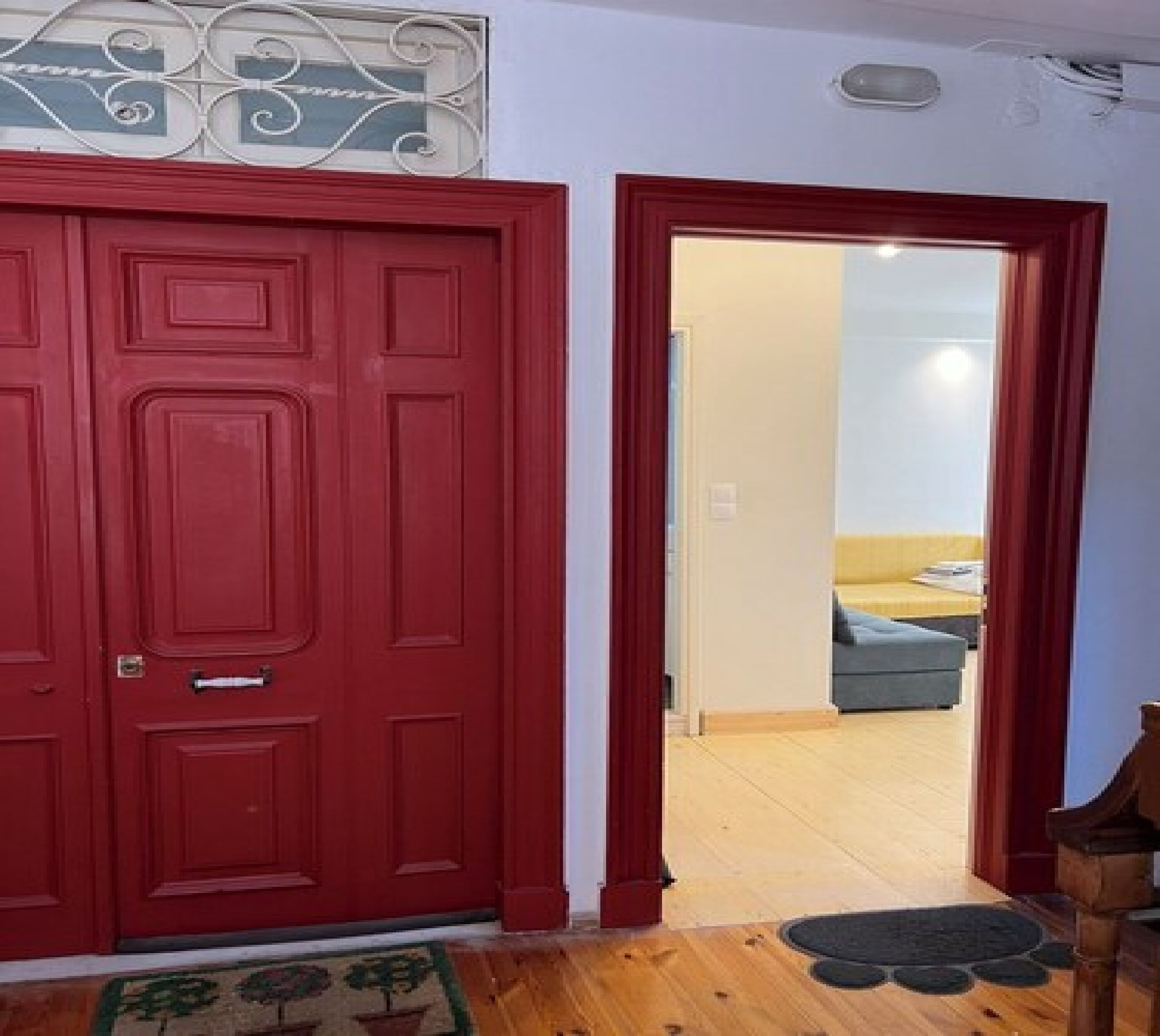 A red door with a decorative glass panel above it.