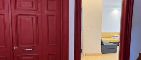 A red door with a decorative glass panel above it.