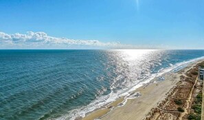 Une plage offrant une vue dégagée sur l’océan et bordée d’un rivage sablonneux.