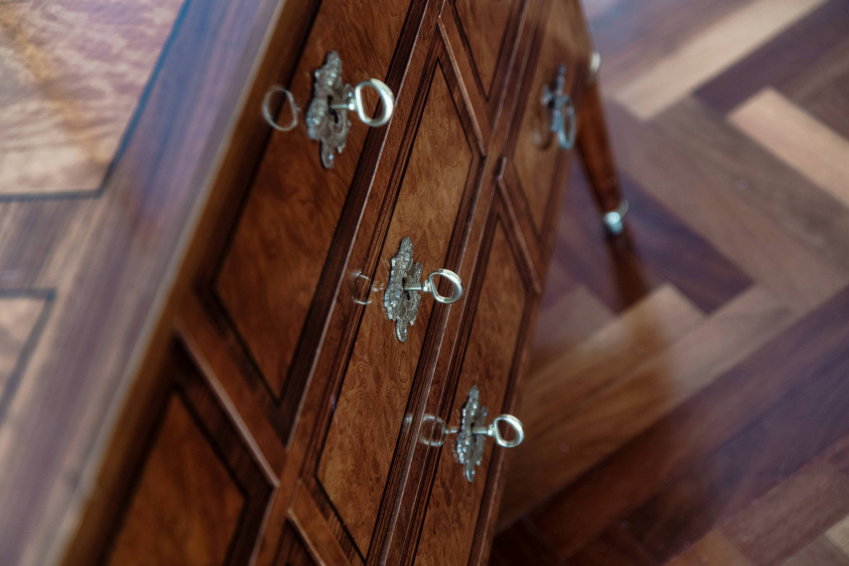 Un meuble en bois doté de poignées métalliques décoratives.
