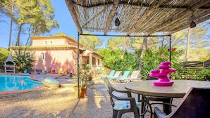 A poolside area with a pergola, lounge chairs, and a table with a decorative item. - Beautiful home in Les Arcs (Les Arcs)