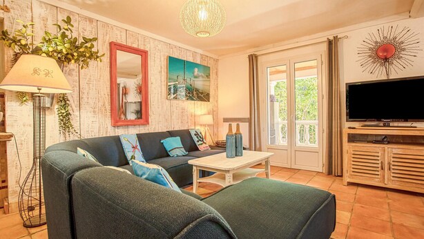 A living room with a sofa, a coffee table, a TV, and a decorative mirror. - Beautiful home in Les Arcs (Les Arcs)