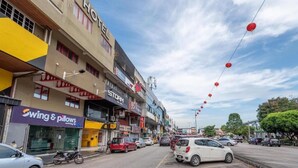 A hotel with a 'HOTEL' sign, a 'STORM' store, and 'Swing & Pillows' across the street. - Swing & Pillows @ PJ SS2 (Petaling Jaya)