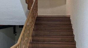 A wooden staircase with a metal railing. - Swing & Pillows @ PJ SS2 (Petaling Jaya)
