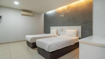 Quarto de hotel com duas camas, um espelho grande e uma luminária moderna.