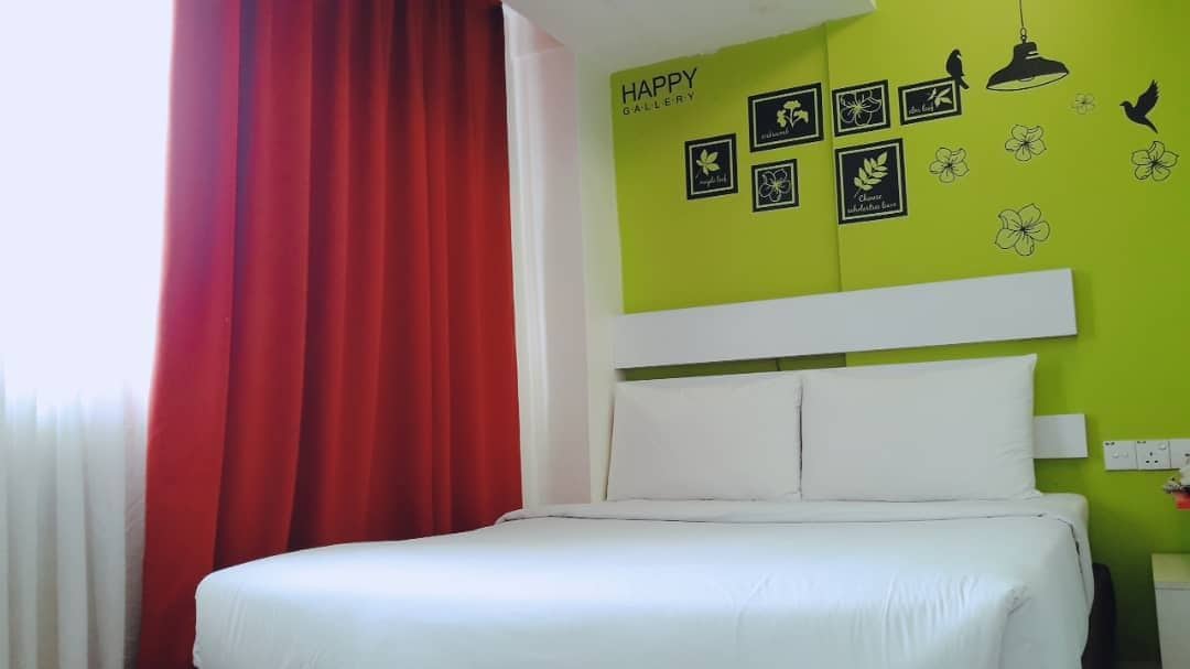 Ein Hotelzimmer mit Bett, roten Vorhängen, einer grünen Wand mit Wandbild und einem weißen Kopfteil.