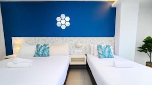 A hotel room with two beds, a blue accent wall, and a logo on the headboard. - Swing & Pillows @ PJ SS2 (Petaling Jaya)