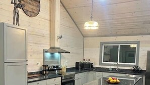 Eine moderne Küche mit einer großen Kochinsel, grauen Schränken und Holzboden.