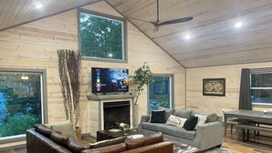Ein modernes Wohnzimmer mit Kamin, Ledersofa und Flachbildfernseher.