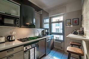 Design appartement | Privékeuken | Een koelkast/vriezer, een magnetron, een oven, een vaatwasser