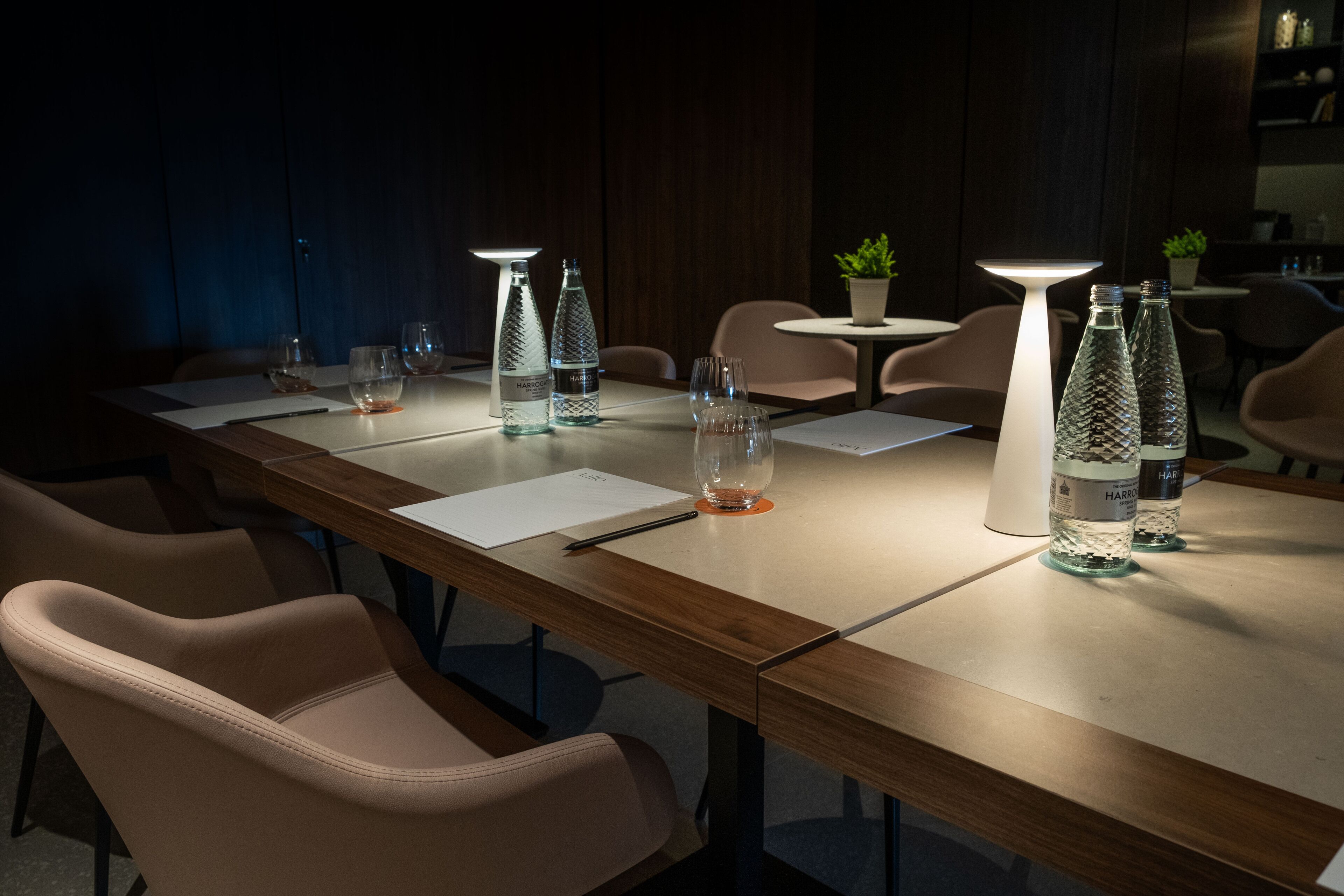 A conference room with a long table, chairs, and glassware.
