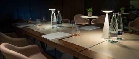 A conference room with a long table, chairs, and glassware.