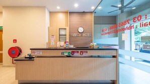 A reception desk at Harbour Hotel with a clock, a fire extinguisher, and a no-smoking sign. - Harbour Hotel (Petaling Jaya)
